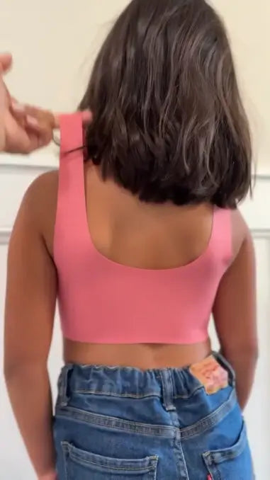 Schiena di una bambina con la brassiere Brassetta rosa: spalline larghe e niente ganci